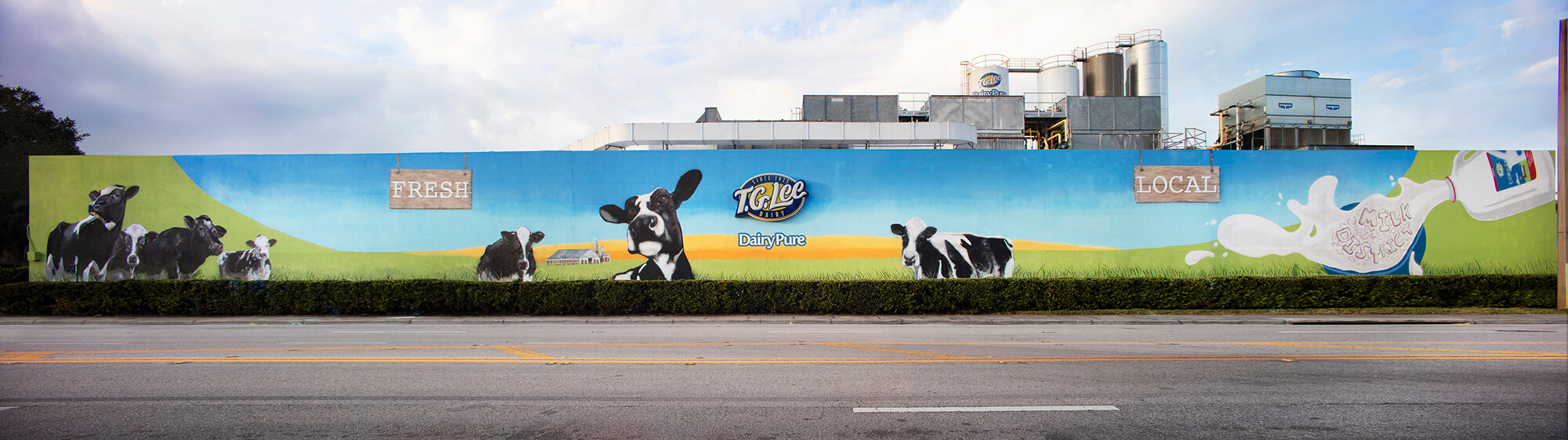 mural of cow on farm land on industrial building