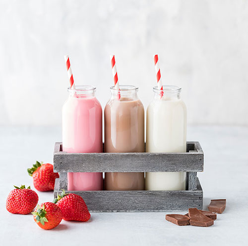 Glasses of strawberry, chocolate, and vanilla milk